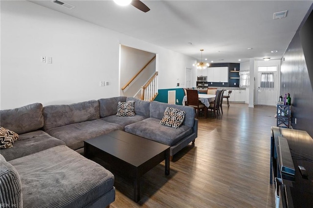 living room featuring hardwood / wood-style flooring and ceiling fan with notable chandelier