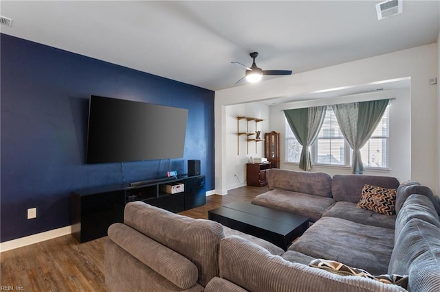 living room with ceiling fan and dark wood-type flooring