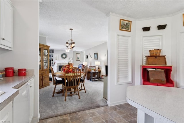 carpeted dining room with a fireplace, crown molding, a textured ceiling, and a chandelier