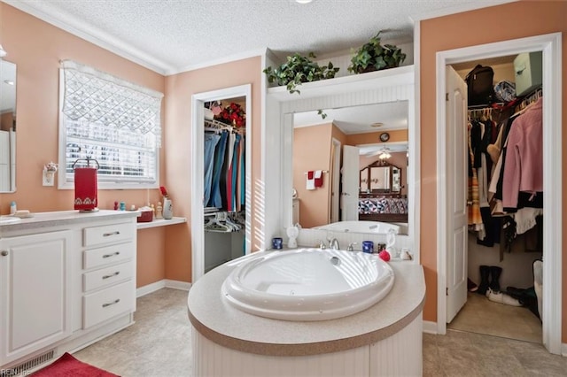 bathroom featuring vanity, a textured ceiling, crown molding, a bath, and tile patterned flooring