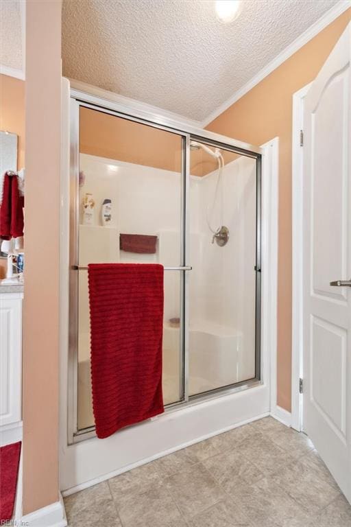 bathroom with an enclosed shower, a textured ceiling, and ornamental molding