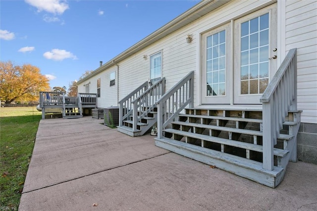 exterior space with central AC unit, a deck, and a yard