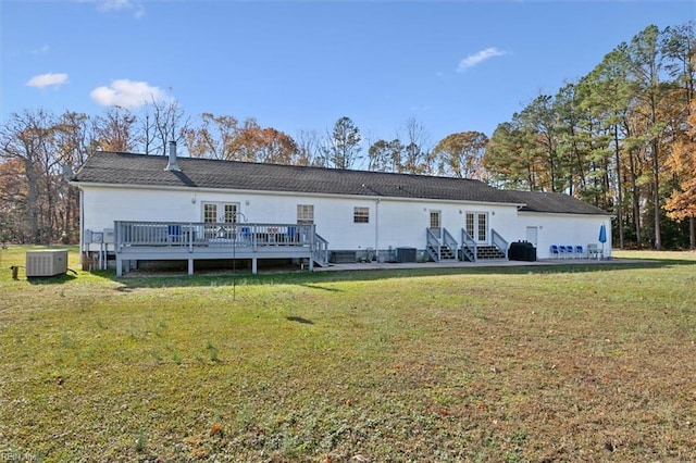 rear view of house with cooling unit, a yard, a wooden deck, and french doors