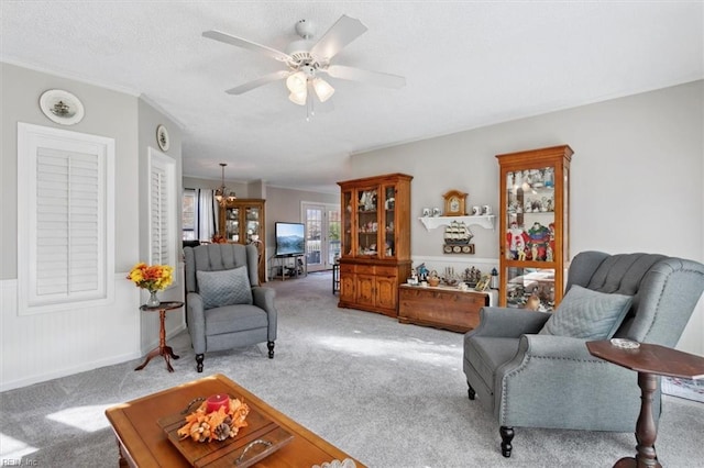 living room featuring light carpet, crown molding, and ceiling fan