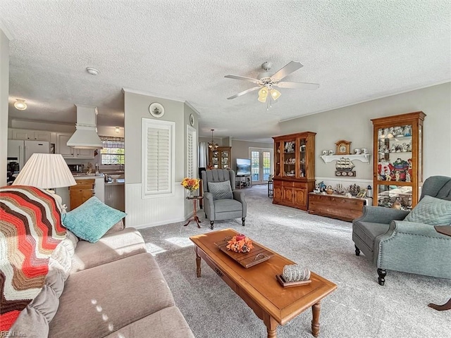 living room with a textured ceiling, ceiling fan, light carpet, and a wealth of natural light