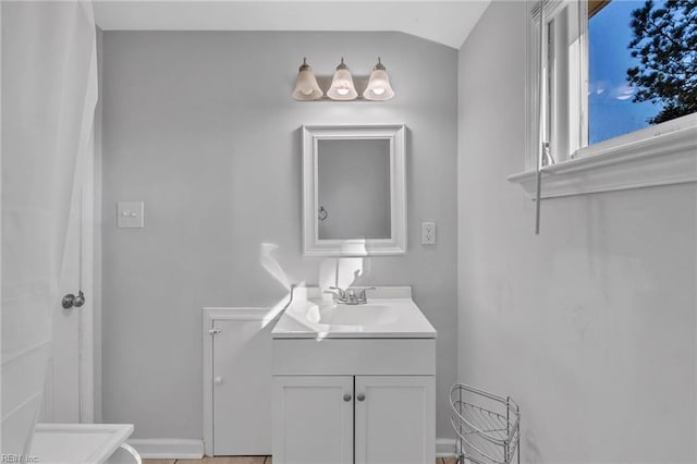 bathroom with vanity and lofted ceiling