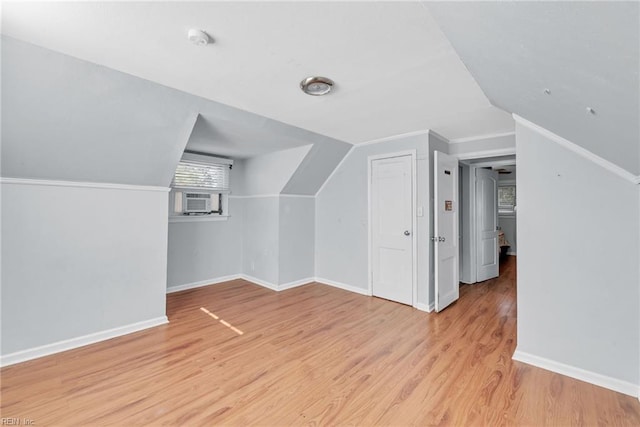 bonus room featuring light wood-type flooring and vaulted ceiling