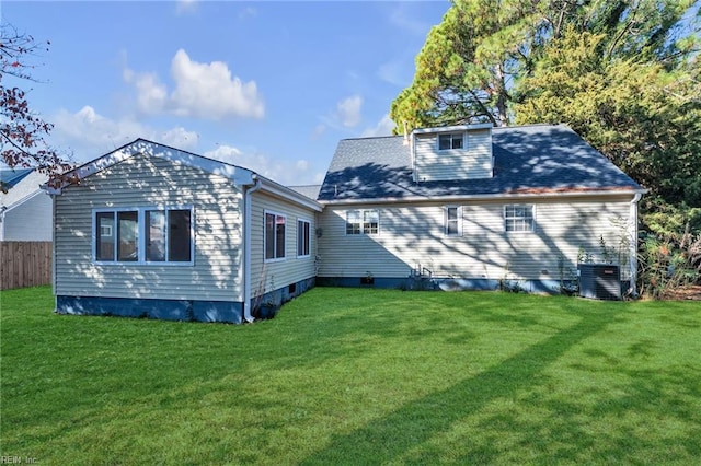 rear view of house with a yard and central AC