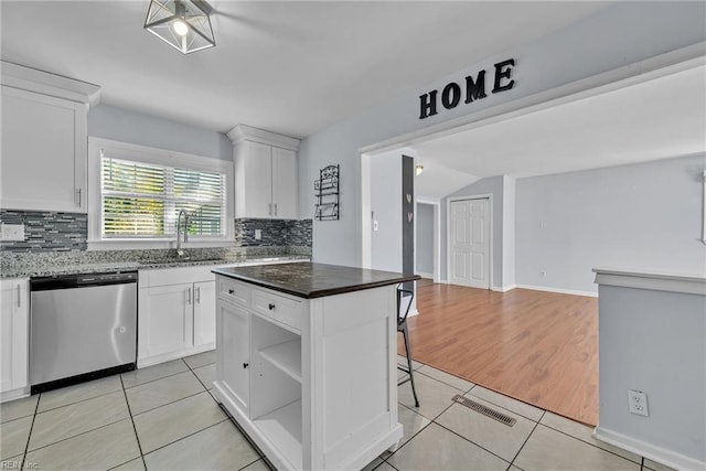 kitchen with backsplash, a kitchen island, sink, dishwasher, and white cabinetry