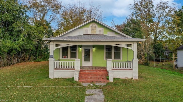 bungalow with covered porch and a front yard