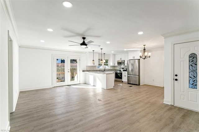 unfurnished living room with crown molding, french doors, light hardwood / wood-style floors, and ceiling fan with notable chandelier