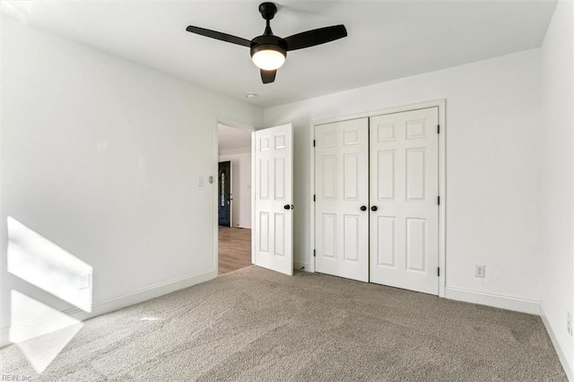 unfurnished bedroom with ceiling fan, a closet, and carpet floors