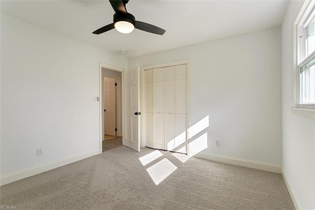 unfurnished bedroom with light carpet, a closet, and ceiling fan