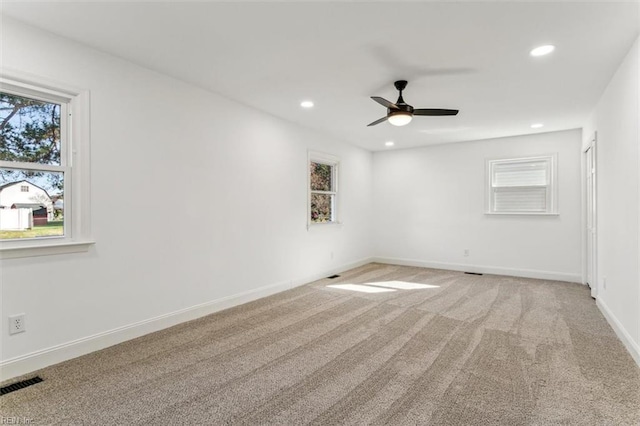 carpeted spare room featuring ceiling fan