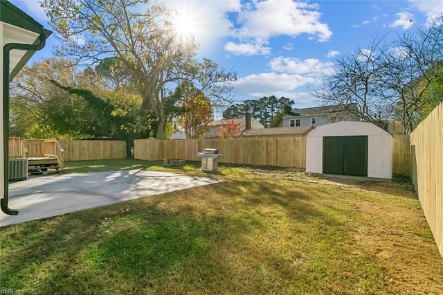 view of yard featuring central AC unit, a storage unit, and a patio area