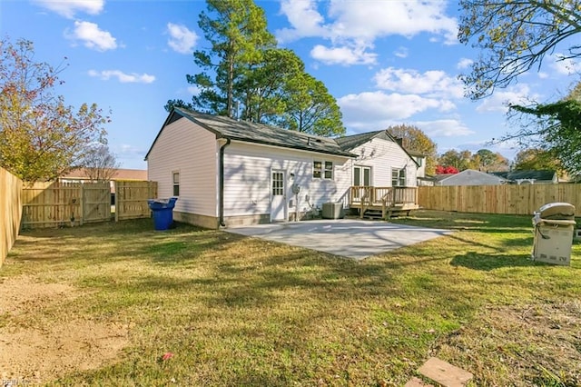 rear view of property featuring a lawn, a deck, and a patio