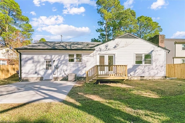 rear view of property featuring a lawn, french doors, a wooden deck, cooling unit, and a patio