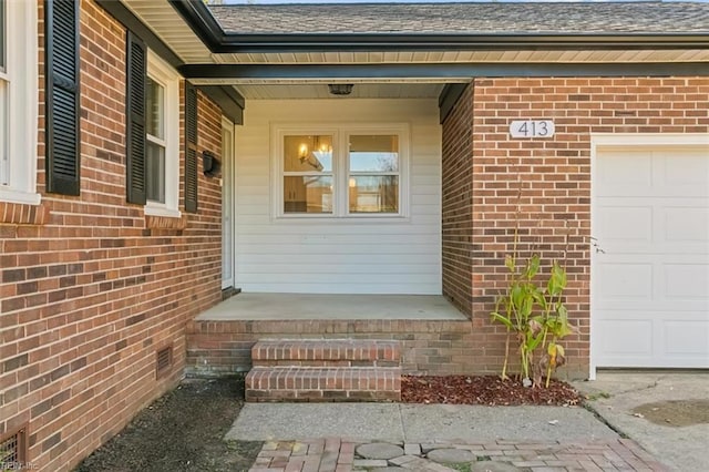 view of exterior entry with covered porch and a garage