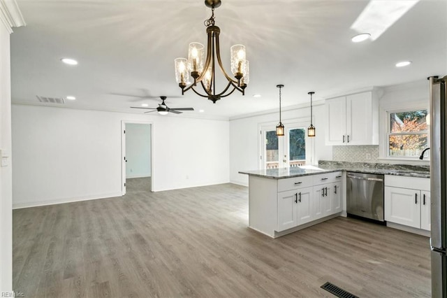 kitchen with hanging light fixtures, hardwood / wood-style floors, white cabinets, ceiling fan with notable chandelier, and appliances with stainless steel finishes