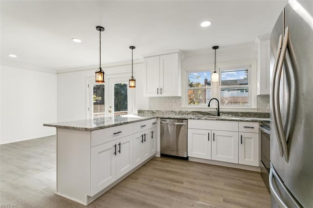 kitchen with stainless steel appliances, white cabinetry, a wealth of natural light, and light hardwood / wood-style floors