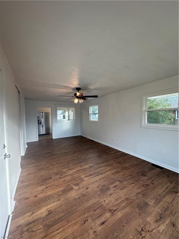 unfurnished room with dark hardwood / wood-style flooring and ceiling fan