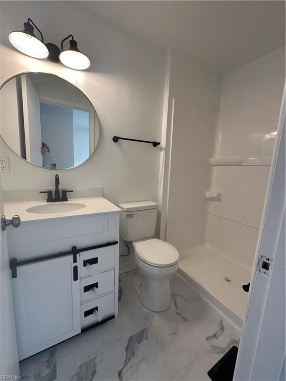 bathroom featuring vanity, toilet, and walk in shower