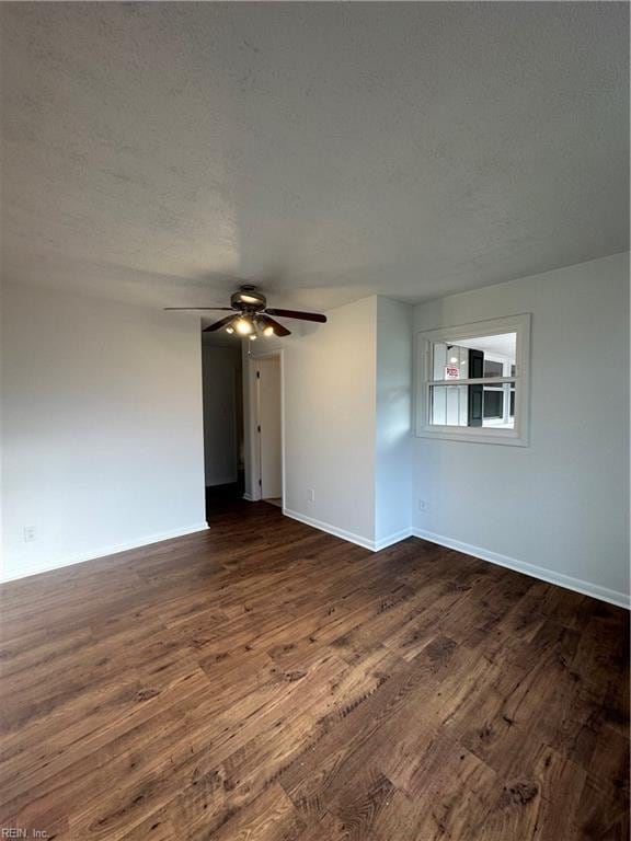 empty room featuring dark hardwood / wood-style floors, ceiling fan, and a textured ceiling