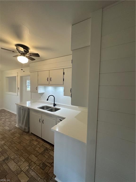 kitchen featuring white cabinetry, ceiling fan, and sink