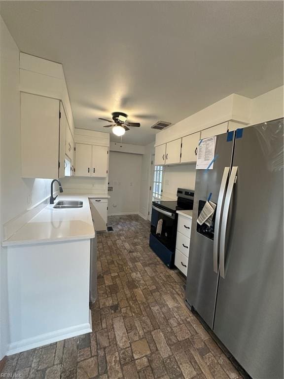 kitchen featuring white cabinets, sink, stainless steel refrigerator with ice dispenser, black electric range, and ceiling fan