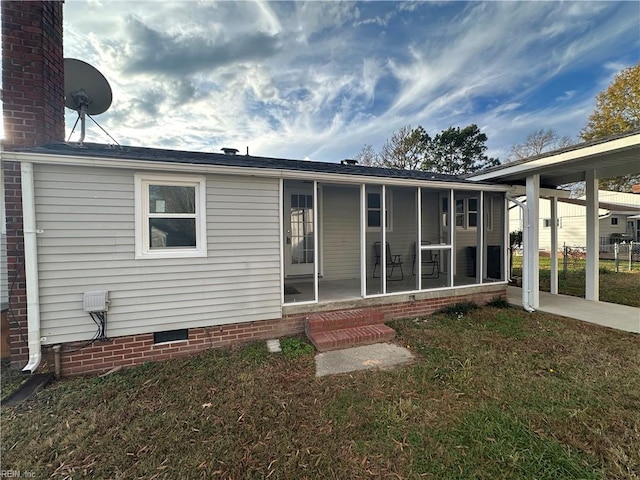 back of property with a yard and a sunroom