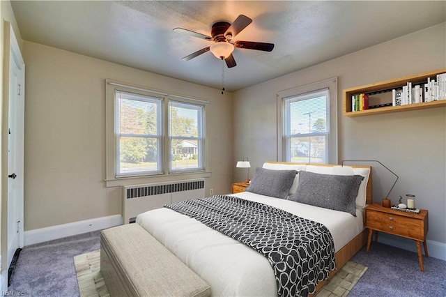 bedroom featuring multiple windows, carpet, radiator, and ceiling fan