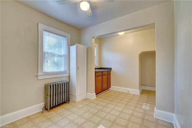 interior space with ceiling fan and radiator