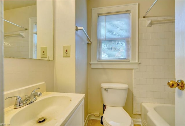 full bathroom with tiled shower / bath, vanity, and toilet