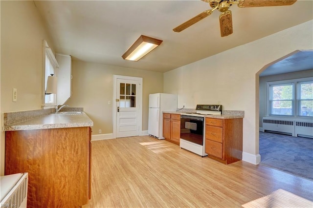 kitchen featuring radiator, ceiling fan, light hardwood / wood-style floors, and white appliances