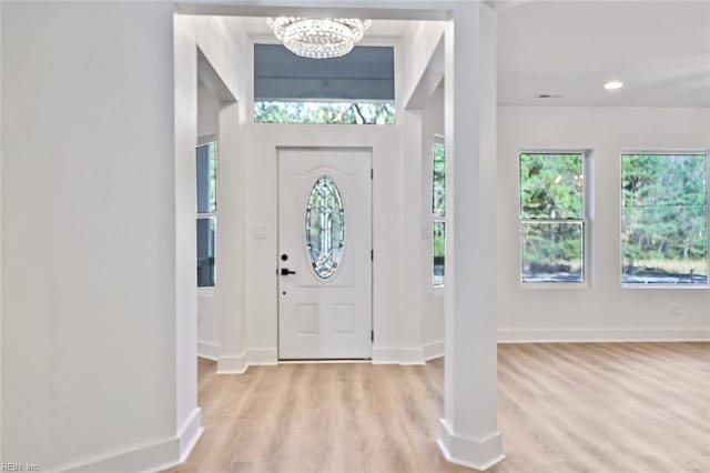 entryway featuring light hardwood / wood-style floors and an inviting chandelier