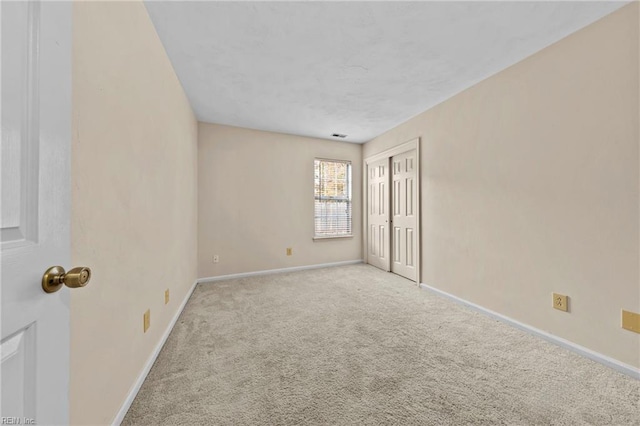 empty room featuring light colored carpet