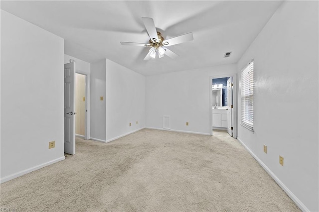 empty room featuring ceiling fan and light carpet