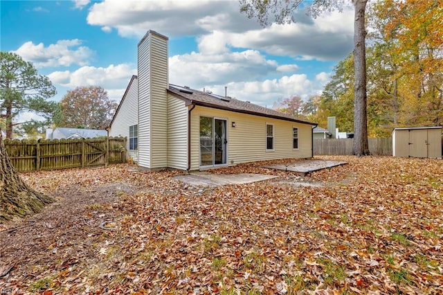 rear view of house with a patio area and a shed