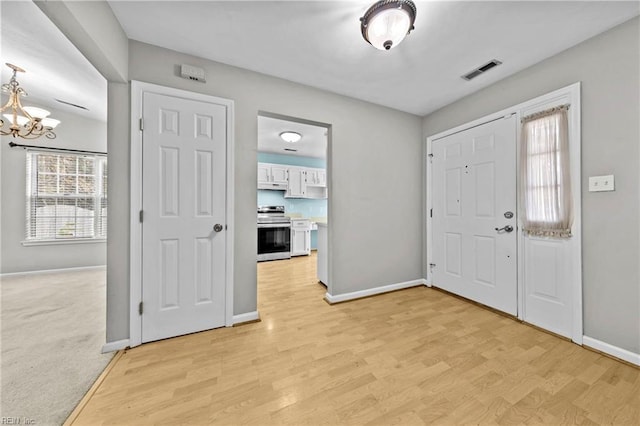 entrance foyer with a notable chandelier and light wood-type flooring