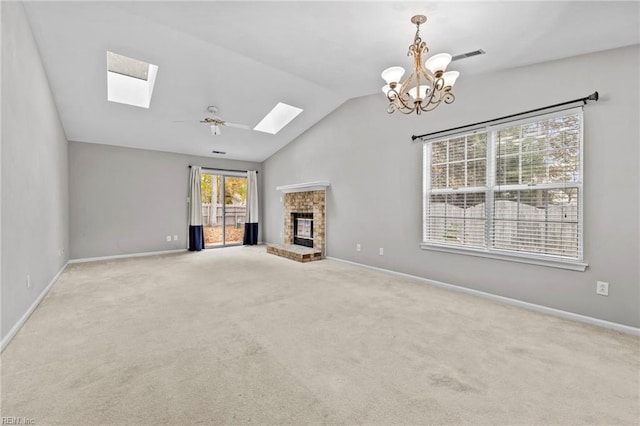 unfurnished living room featuring vaulted ceiling, carpet, ceiling fan with notable chandelier, and a brick fireplace