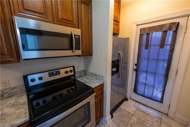 kitchen featuring light stone counters and stainless steel appliances