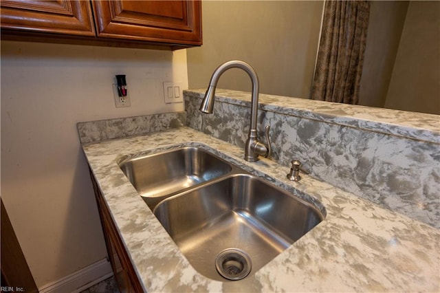 room details featuring light stone counters and sink