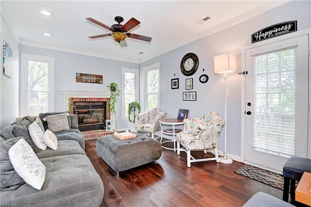 living room featuring a wealth of natural light, ceiling fan, dark hardwood / wood-style floors, and a brick fireplace