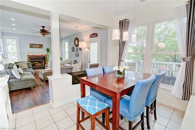 dining room featuring plenty of natural light, light hardwood / wood-style floors, a fireplace, and ceiling fan