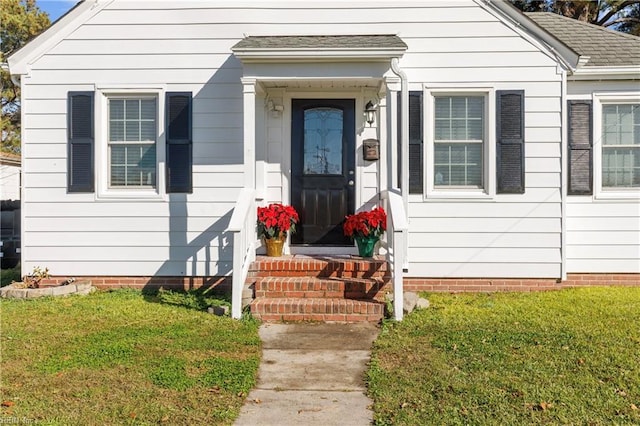 entrance to property featuring a yard