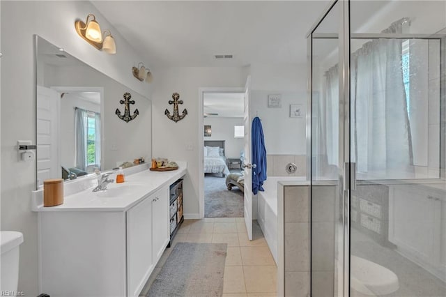 bathroom featuring tile patterned flooring, vanity, a shower with shower door, and toilet