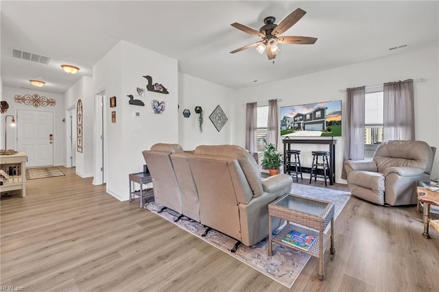 living room featuring ceiling fan and light hardwood / wood-style flooring