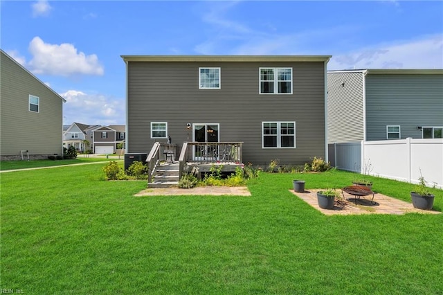 rear view of house featuring central air condition unit, a yard, a deck, and an outdoor fire pit