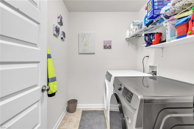 laundry area with independent washer and dryer and light tile patterned floors