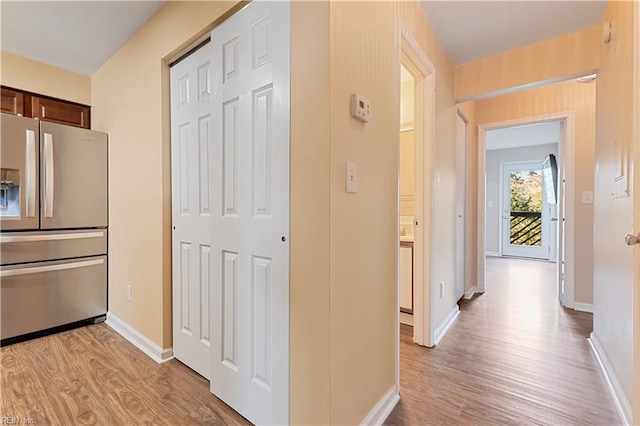 hallway with light wood finished floors and baseboards